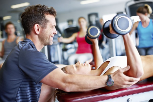 Exercices avec des haltères sur la poitrine pour les filles dans la salle de gym, à la maison